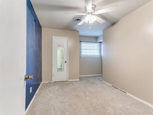 carpeted spare room featuring ceiling fan