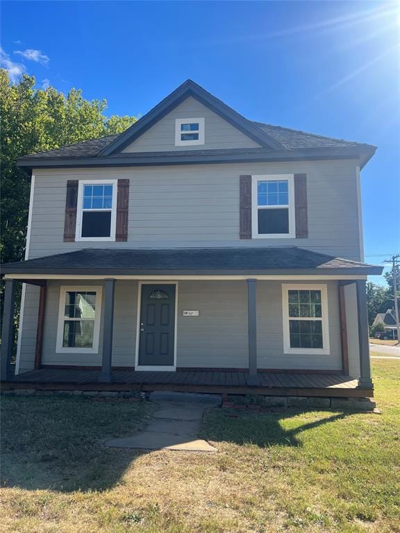 view of front facade featuring covered porch and a front lawn