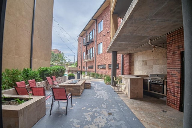 view of patio / terrace featuring area for grilling, a fire pit, and exterior kitchen