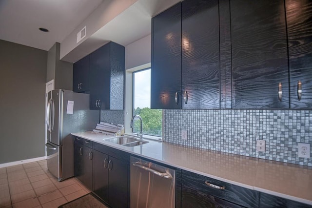 kitchen with light tile patterned flooring, stainless steel appliances, tasteful backsplash, and sink