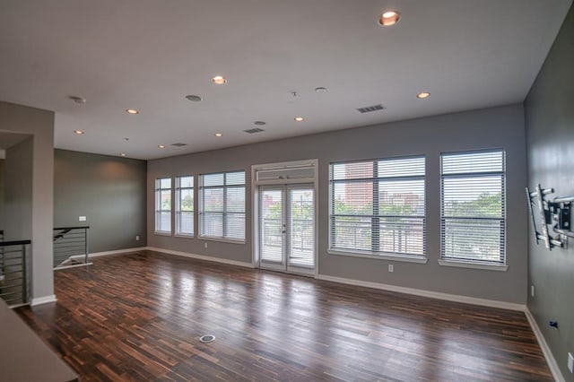 spare room featuring a wealth of natural light and dark hardwood / wood-style flooring