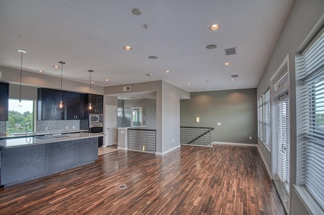 kitchen featuring dark hardwood / wood-style flooring, decorative light fixtures, stainless steel appliances, and backsplash