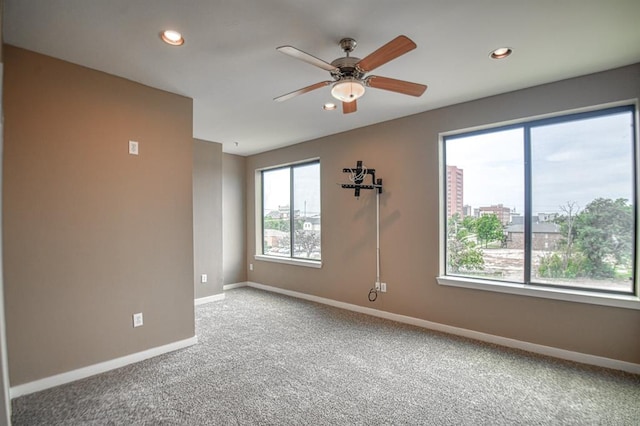 carpeted empty room with plenty of natural light and ceiling fan