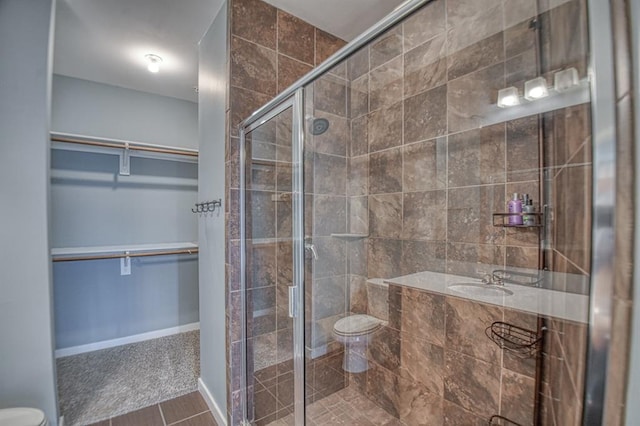 bathroom with tile patterned flooring, toilet, and a shower with door