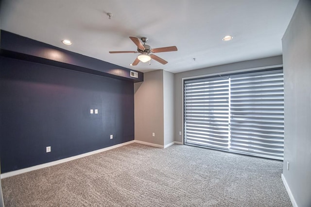 carpeted spare room featuring ceiling fan