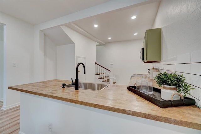 kitchen with hardwood / wood-style flooring, green cabinetry, and sink