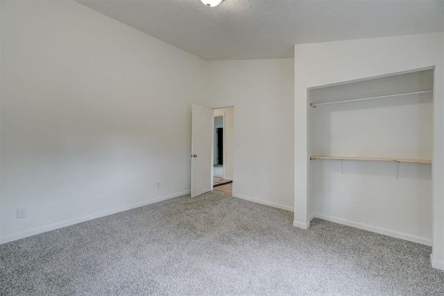 unfurnished bedroom featuring light colored carpet and a closet