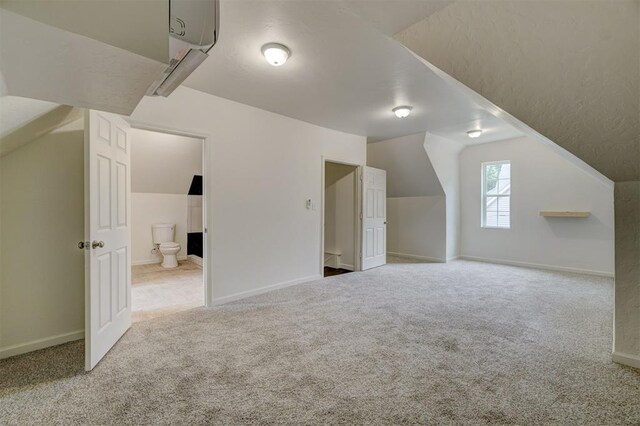 bonus room featuring carpet floors and vaulted ceiling