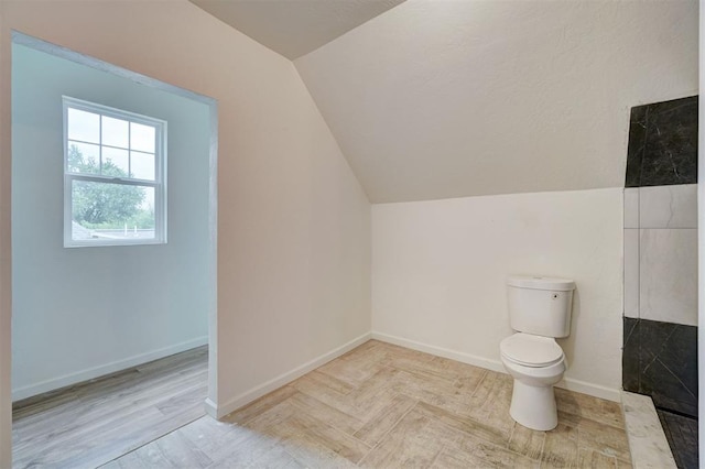 bathroom with hardwood / wood-style floors, vaulted ceiling, and toilet