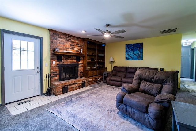 living room with a fireplace, light colored carpet, and ceiling fan