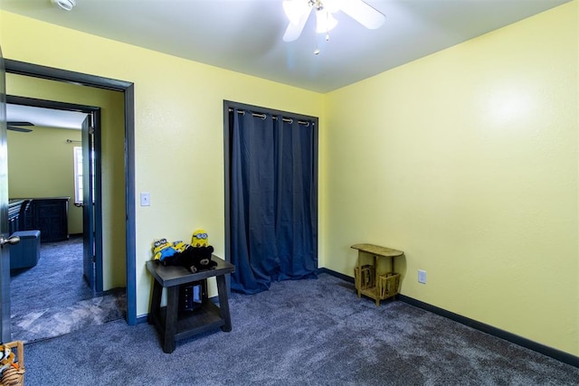 miscellaneous room featuring ceiling fan and dark carpet