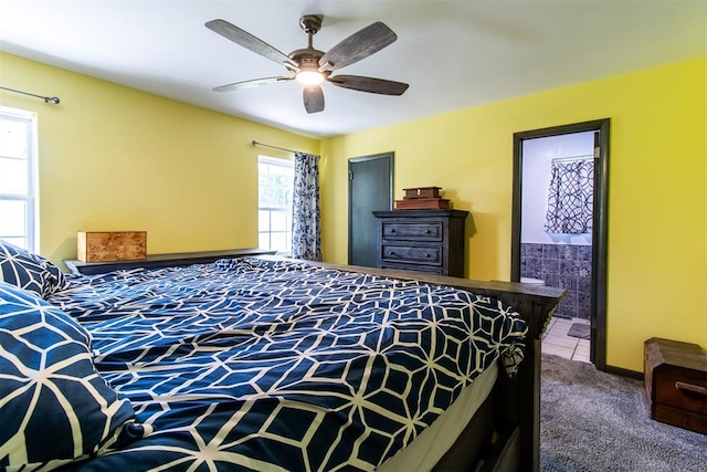 carpeted bedroom featuring ensuite bath and ceiling fan