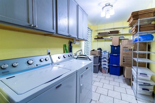 laundry room with washer and clothes dryer, cabinets, and light tile patterned floors