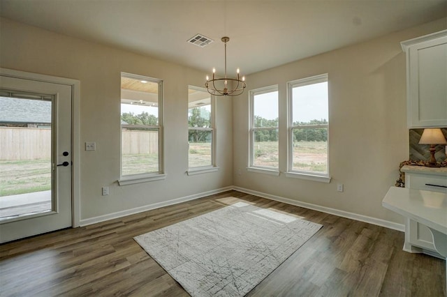 dining space with wood-type flooring and an inviting chandelier