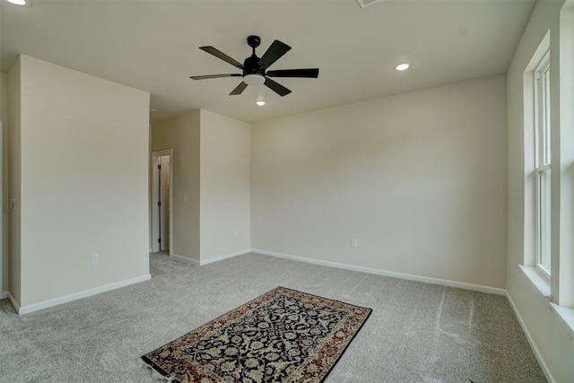 empty room featuring ceiling fan and light carpet