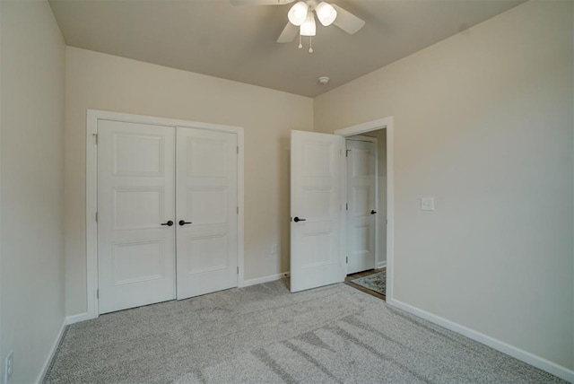 unfurnished bedroom with ceiling fan, light colored carpet, and a closet