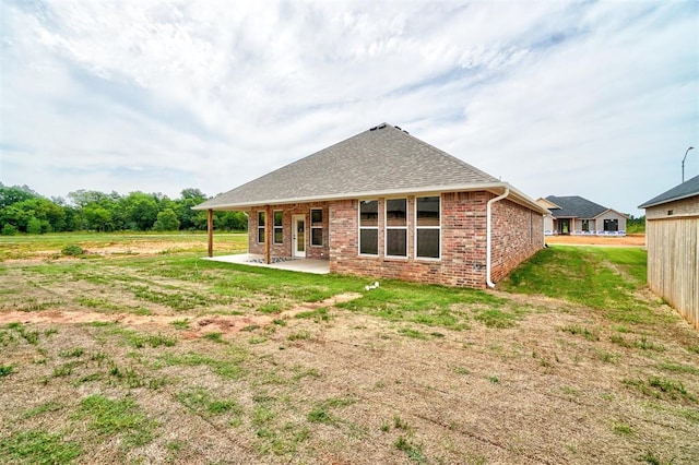 rear view of property featuring a yard and a patio