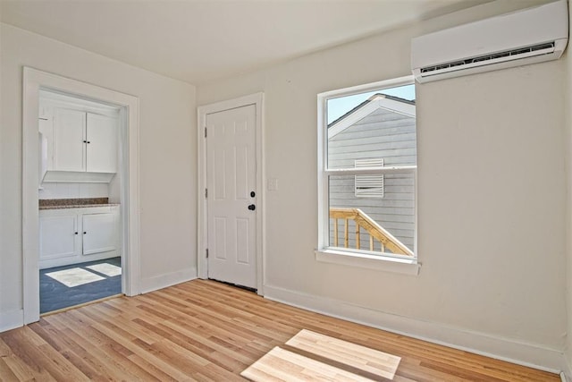 spare room featuring light wood-type flooring and a wall mounted AC