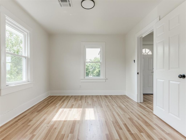 unfurnished room featuring a wealth of natural light and light hardwood / wood-style flooring