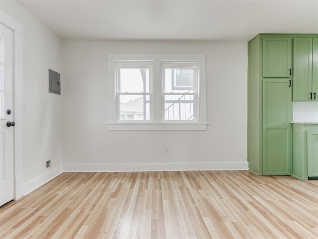 interior space featuring electric panel and light hardwood / wood-style flooring