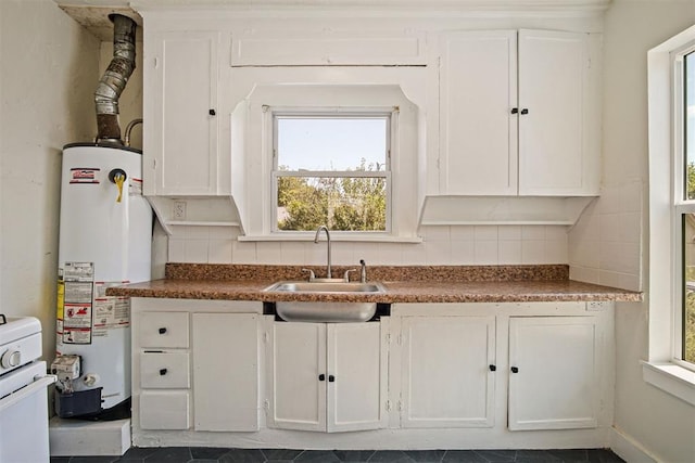 kitchen with sink, white cabinetry, backsplash, and water heater