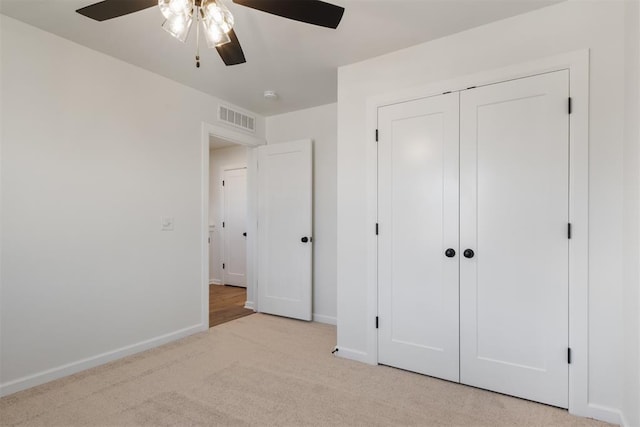 unfurnished bedroom featuring a closet, ceiling fan, and light colored carpet