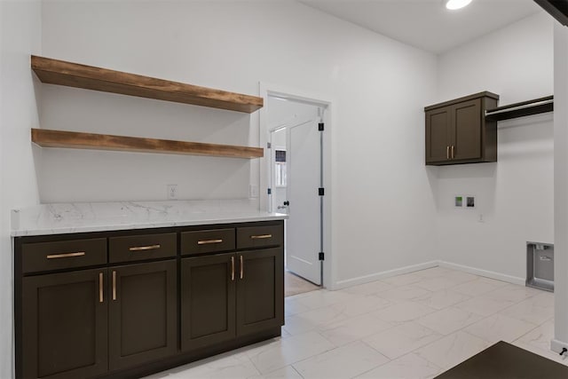 kitchen with dark brown cabinetry and light stone counters