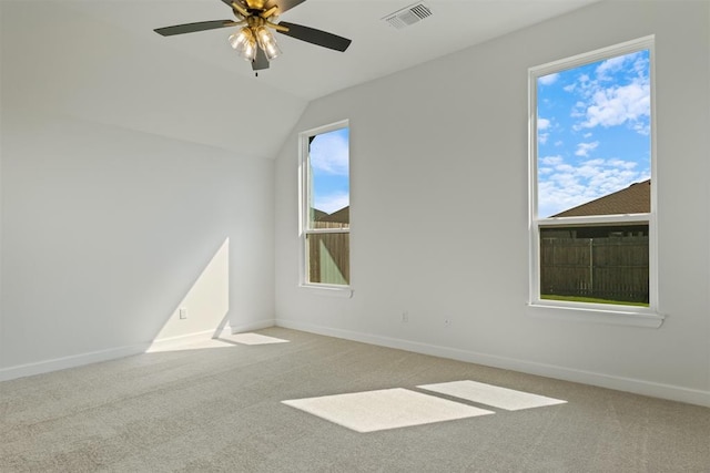 empty room featuring light carpet, vaulted ceiling, and ceiling fan