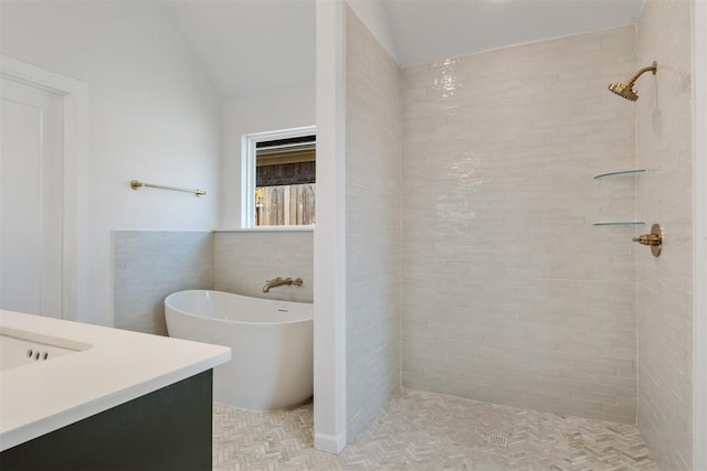 bathroom featuring vanity, vaulted ceiling, tile walls, and independent shower and bath