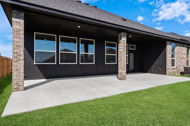 back of property featuring a yard, cooling unit, and a patio