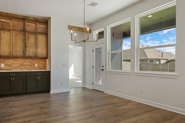 unfurnished dining area with dark hardwood / wood-style flooring and a chandelier