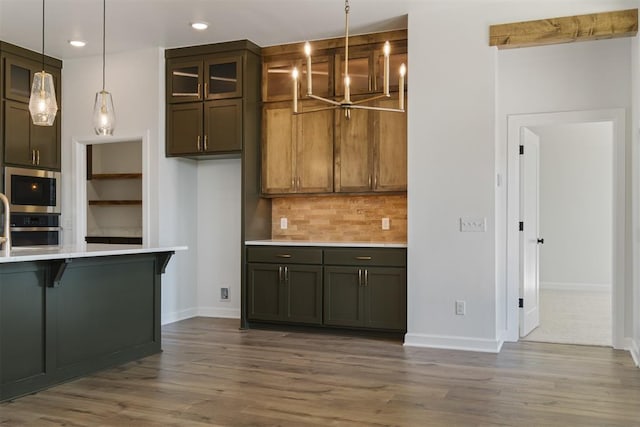 kitchen featuring decorative backsplash, dark wood-type flooring, pendant lighting, and appliances with stainless steel finishes