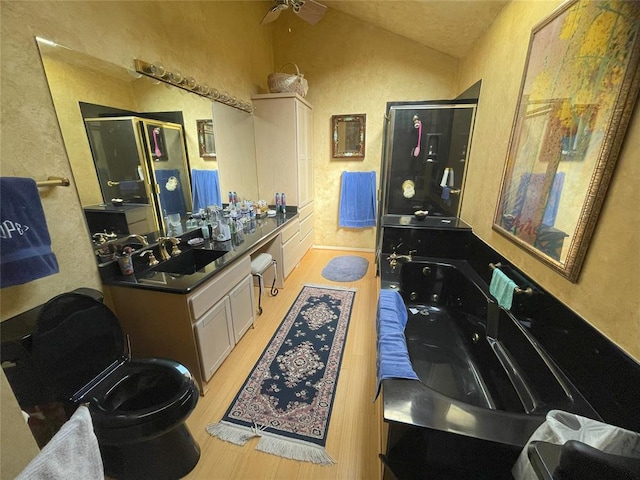 bathroom with vanity, lofted ceiling, ceiling fan, separate shower and tub, and wood-type flooring