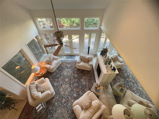 living room featuring a high ceiling, french doors, and hardwood / wood-style floors