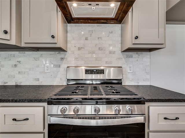 kitchen with white cabinets, gas stove, and extractor fan