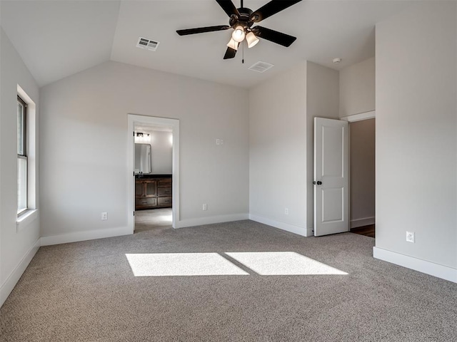 unfurnished bedroom with connected bathroom, carpet floors, vaulted ceiling, and ceiling fan