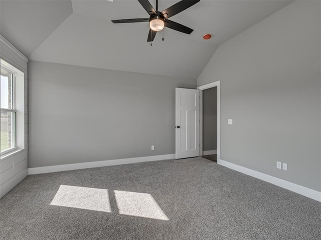 spare room with carpet flooring, vaulted ceiling, and ceiling fan