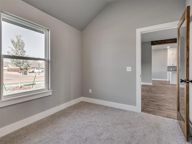 unfurnished room with hardwood / wood-style flooring and lofted ceiling