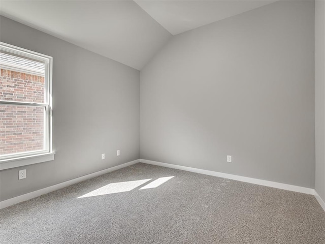 unfurnished room featuring carpet, vaulted ceiling, and a healthy amount of sunlight