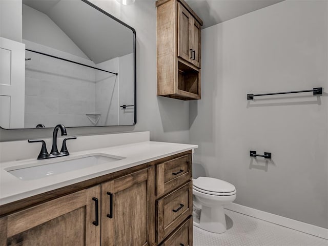 bathroom with toilet, vanity, tile patterned floors, and lofted ceiling