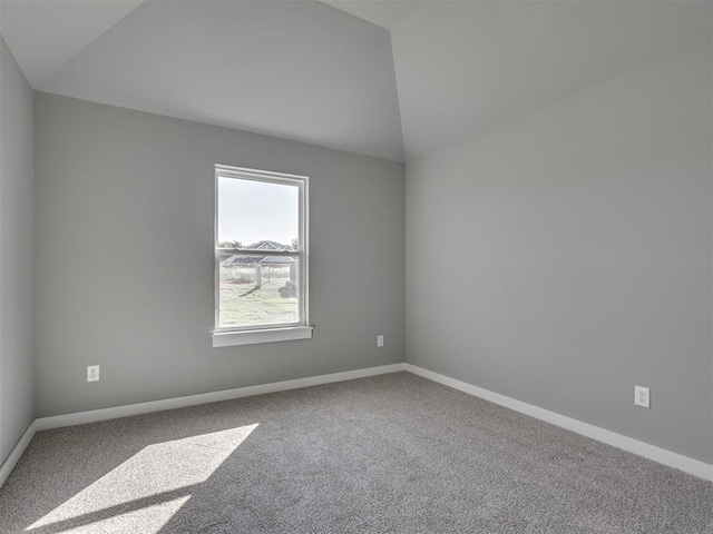 empty room featuring lofted ceiling and carpet floors