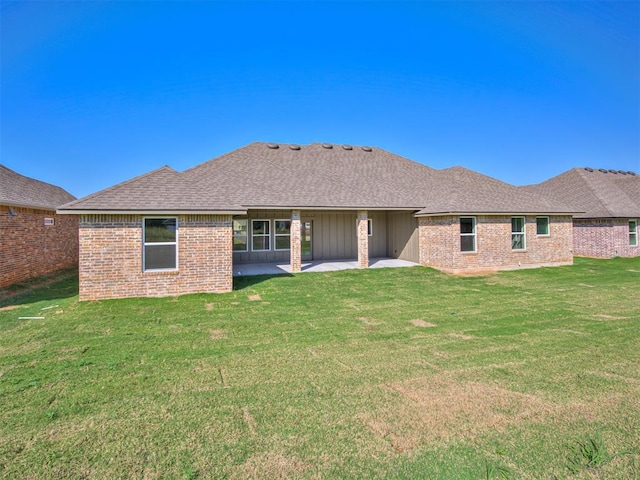 back of property with a yard and a patio