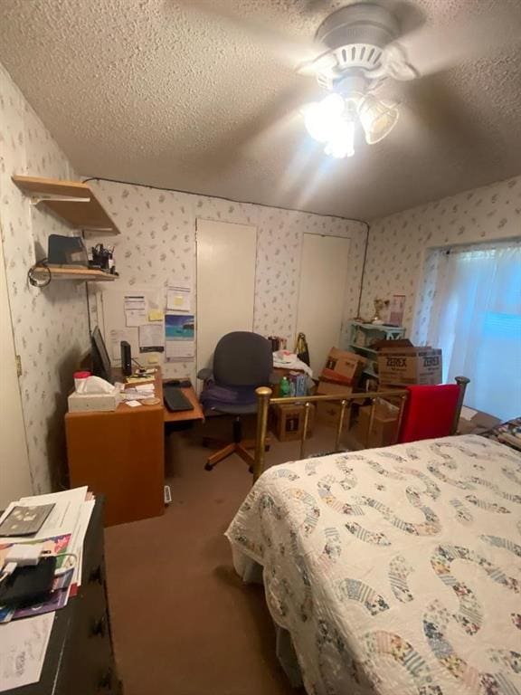 bedroom with ceiling fan, carpet floors, and a textured ceiling