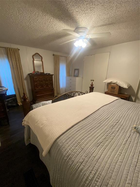 bedroom with ceiling fan and a textured ceiling