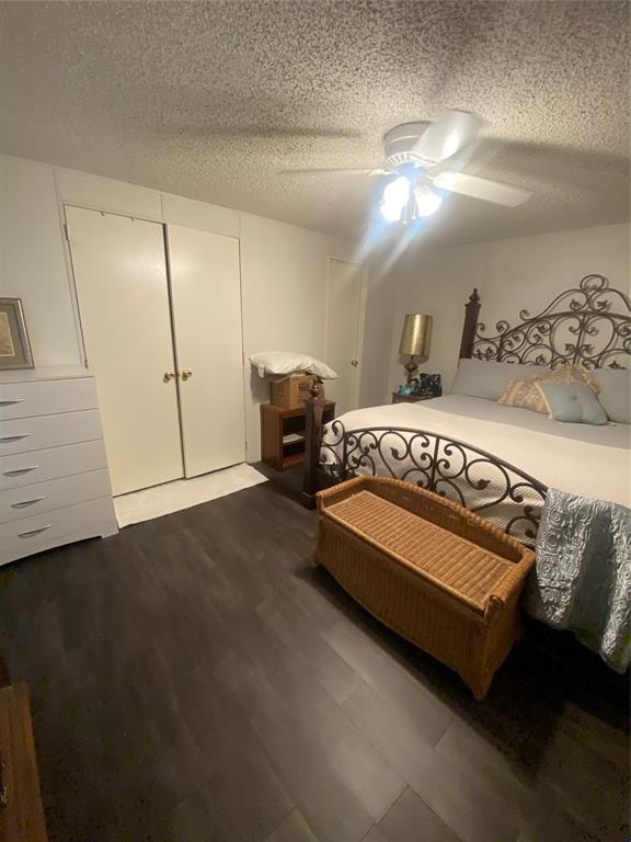 bedroom featuring a textured ceiling, ceiling fan, a closet, and dark hardwood / wood-style floors