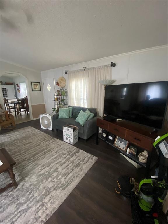 living room with ornamental molding and dark wood-type flooring