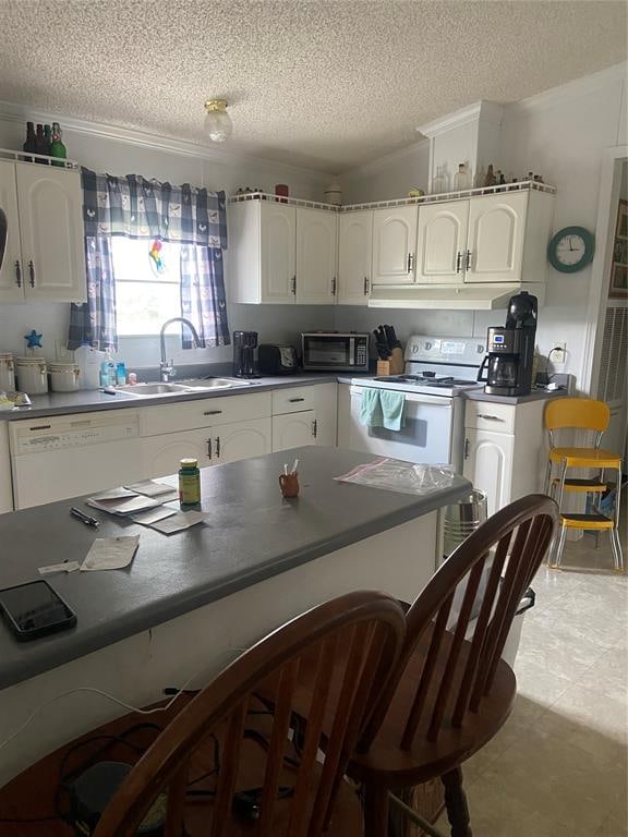 kitchen featuring white cabinets, white appliances, and sink