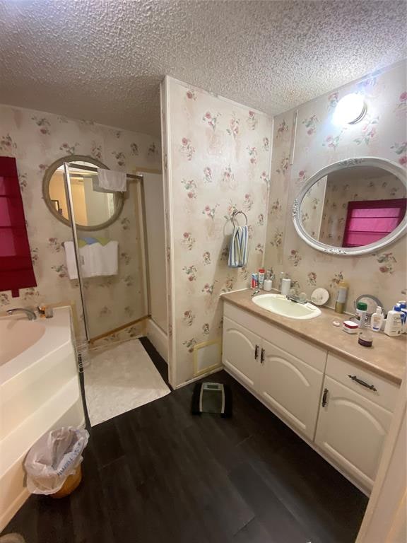 bathroom with hardwood / wood-style floors, vanity, and a textured ceiling