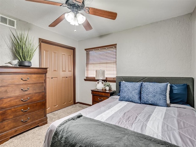 bedroom with light colored carpet, a closet, and ceiling fan