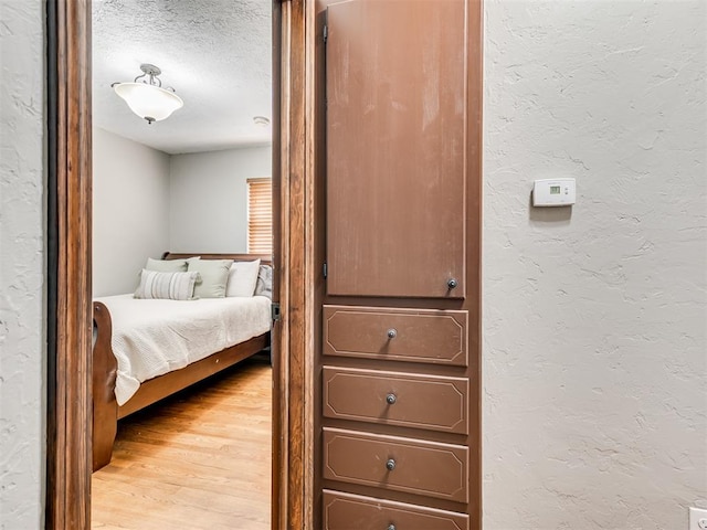 bedroom with hardwood / wood-style floors and a textured ceiling